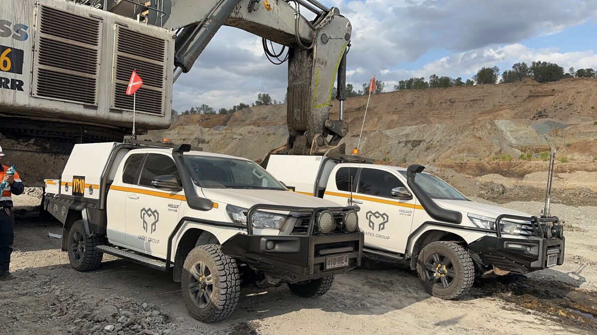Yates Group utes with a hydraulic excavator on a mine bench