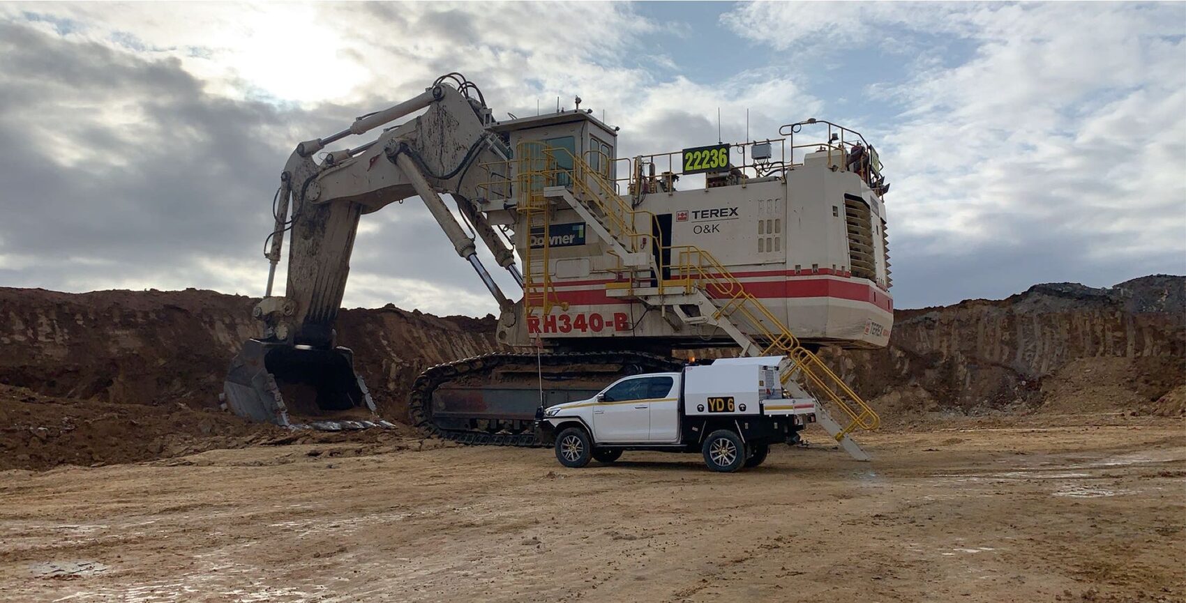 Yates Group service ute beside a large hydraulic excavator during a morning inspection
