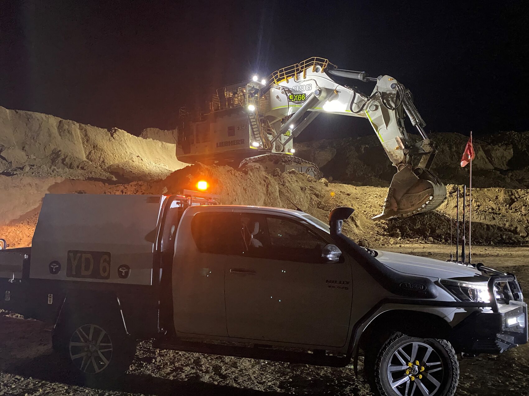 Yates Group ute in front of a working excavator at dusk